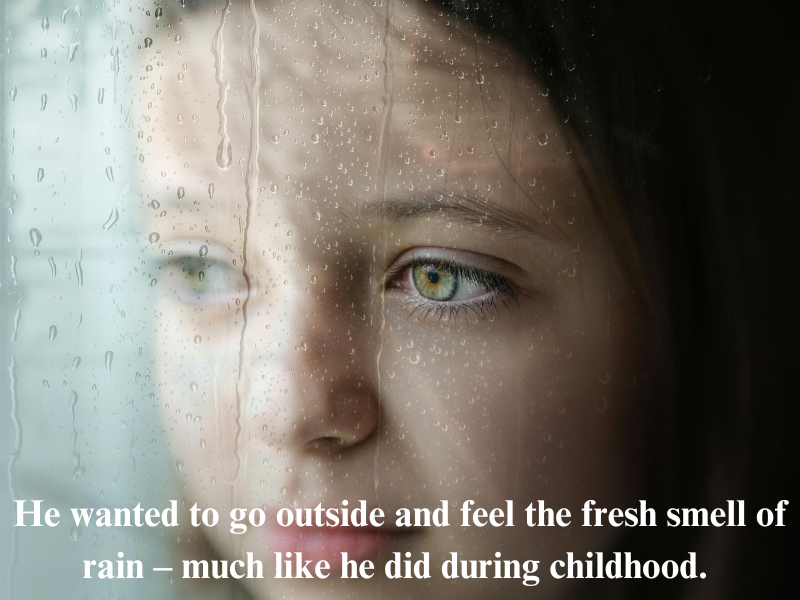 Girl with green eyes watching rain through window